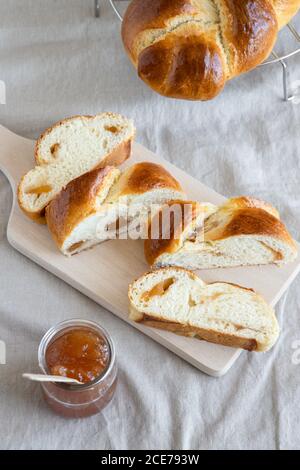 Du dessus de brioche fraîche à base de pâte au beurre avec bourrage sur le panneau en bois à côté du pot de verre de bourrage Banque D'Images