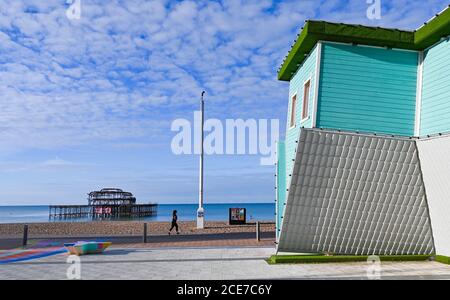 Brighton Royaume-Uni 31 août 2020 - UN coureur passe devant la maison à l'envers sur le front de mer de Brighton lors d'une belle matinée ensoleillée pour commencer le lundi de vacances d'août. La prévision est pour elle être beaucoup plus frais que la normale dans certaines parties de la Grande-Bretagne aujourd'hui : crédit Simon Dack / Alamy Live News Banque D'Images