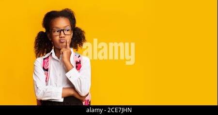 Une écolière africaine réfléchie pense aux problèmes scolaires, Studio Shot, Panorama Banque D'Images