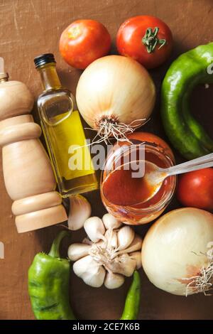 Composition vue de dessus avec sauce tomate dans un pot placé au milieu légumes frais et huile d'olive aux épices préparées pour la cuisson Sauce bolognaise Banque D'Images