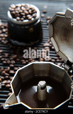Café dans la cafetière et grains de café sur la table Banque D'Images