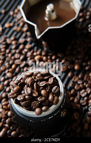 Café dans la cafetière et grains de café sur la table Banque D'Images