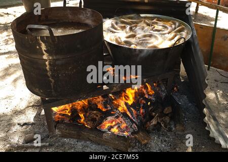 Processus de cuisson des saucisses de sang dans une casserole en fer sur feu de joie dans une usine de viande traditionnelle dans une zone rurale Banque D'Images