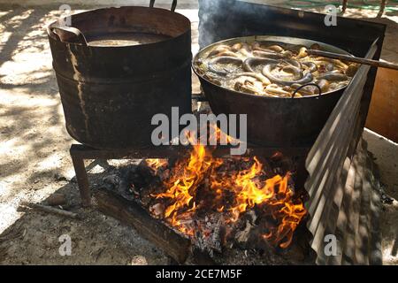 Processus de cuisson des saucisses de sang dans une casserole en fer sur feu de joie dans une usine de viande traditionnelle dans une zone rurale Banque D'Images