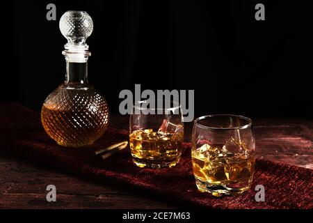 Gros plan de deux verres de whisky sur une table et une bouteille de whisky Banque D'Images
