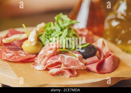 Carte de charcuterie avec jambon prosciutto, salami, herbes et antipasti aux olives. Plats gastronomiques Banque D'Images