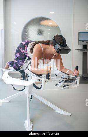 Femme renforçant ses muscles avec un entraînement VR innovant Banque D'Images