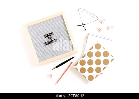 Citation Retour à l'école. Plat en carton, verres, papeterie, blocs-notes sur bureau blanc Banque D'Images