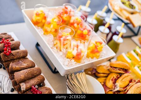 Verres à grand angle avec salade de fruits rafraîchissante à base de assortiment de fruits colorés servis sur un plateau avec glace Banque D'Images
