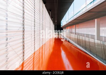 Plancher de passage orange brillant dans un bâtiment moderne en béton Banque D'Images