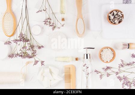 Accessoires écologiques frais et cosmétiques pour la salle de bains avec brindilles et décorations lavande élégantes sur fond blanc, vue du dessus. Banque D'Images