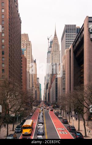 New York avec circulation des transports sur route droite menant entre les bâtiments modernes de haute élévation au printemps soir Banque D'Images