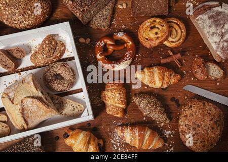 Vue de dessus des petits pains faits maison et des pains avec croissants et autre boulangerie sur table en bois Banque D'Images