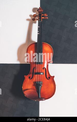 De dessus de violon brillant avec des cordes placées sur les échecs plancher de motif de planche Banque D'Images