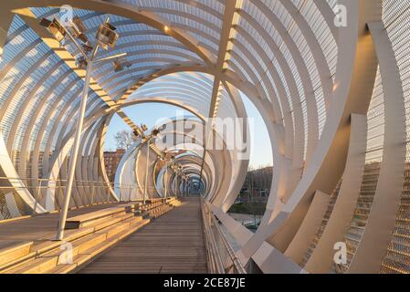 Perspective à l'intérieur du passage de cône hélicoïdal en forme de pont Arganzuela avec spirales métalliques internes entrelacées se croisant en diagonale au coucher du soleil Madrid Banque D'Images