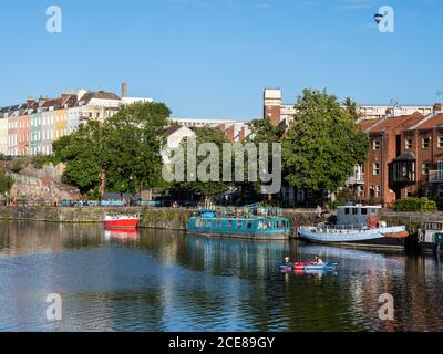 Un ballon d'air chaud flotte sur les Bristol Docks régénérés, où un couple rangée un bateau gonflable. Banque D'Images