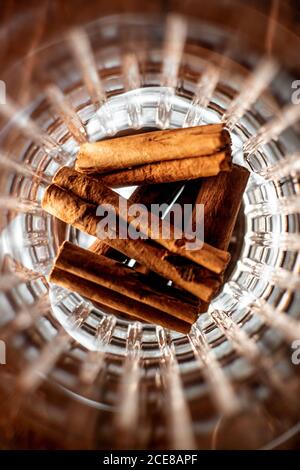 Vue de dessus d'une pile de bâtons de cannelle aromatiques placés à l'intérieur verre dans la barre Banque D'Images