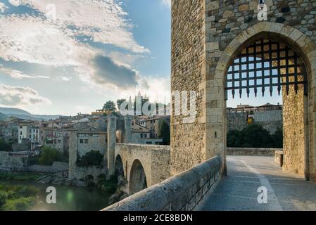 Ancien pont en pierre avec passage voûté avec passage de clôture en métal rivière et menant à des bâtiments historiques de la ville médiévale de Besalu En Espagne Banque D'Images