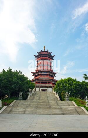 Vue pittoresque à angle bas sur le magnifique escalier d'un bâtiment ornemental De pagode chinoise traditionnelle encadrée par des branches d'arbre vert contre Ciel bleu ciel nuageux en été à Xiamen en Chine Banque D'Images