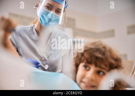 Dentiste pédiatrique attentif prenant soin d'un jeune patient