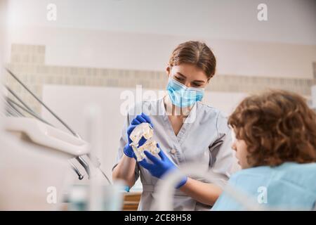 Enfant dans un bureau de dentistes apprendre comment l'hygiène dentaire fonctionne Banque D'Images