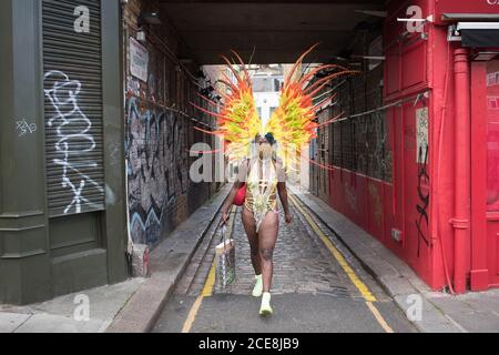 Une femme en costume se dirigeant vers le carnaval de Notting Hill en ligne, dans le nord de Londres, après l'annulation du carnaval de 2020 en raison de la pandémie du coronavirus, avec des événements diffusés en ligne. Banque D'Images