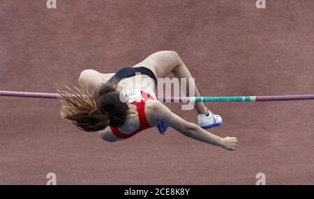 Athlète sautant au-dessus de la barre dans le sport de saut de poteau Banque D'Images