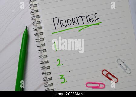 Les priorités sont à noter sur un pense-bête. Supporté par une table en bois isolée de services supplémentaires. Banque D'Images