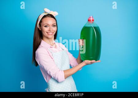 Portrait d'elle belle jolie jolie gaie gaie femme de chambre transport tenir dans les mains savon liquide ustensile bouteille de produit chimique isolée trop lumineux Banque D'Images