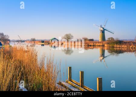 Une aube tranquille sur la rivière Thurne dans les Norfolk Broads avec la pompe à vent de niveau de St Benet. Banque D'Images