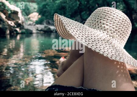 une femelle méconnaissable cassant un œuf de poulet frais dans un bol pendant la cuisson pâtisserie dans une table en bois avec des ingrédients frais Banque D'Images