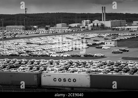Volkswagen Group Rus, Russie, Kaluga - 24 MAI 2020 : rangées d'une nouvelle voiture garée dans un centre de distribution avec train en premier plan et usine automobile en marche Banque D'Images