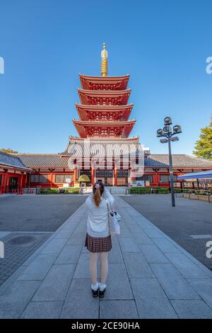 Une fille prenant une photo de la pagode de cinq étages Asakusha Shinto sanctuaire. Banque D'Images