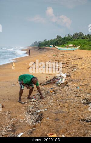 Sri Lanka, Waduwa, pollution sur la plage. Plastique. Pêcheur pauvre collectant des éléments et des coquilles utiles. Banque D'Images