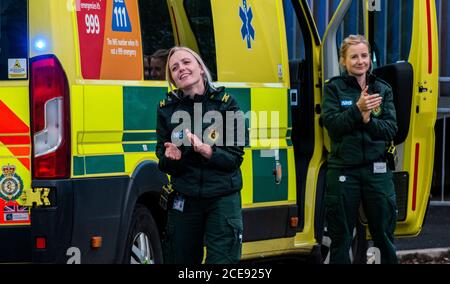 Deux ambulanciers paramédicaux se claquant à l'extérieur de l'hôpital Harrogate, qui participent à Clap pour nos soignants. Banque D'Images