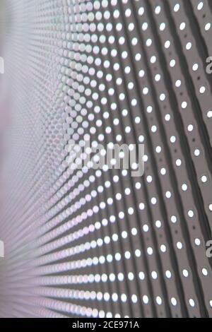 Gros plan d'un mur à LED où vous pouvez voir les diodes électroluminescentes disposées de manière uniforme sur de nombreuses lignes. Banque D'Images