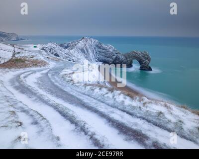 L'arche de roche de la porte Durdle recouverte de neige. Banque D'Images