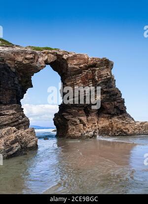 Formation rocheuse en forme d'arche sur la plage de Las Catedrales en Galice en Espagne. Banque D'Images