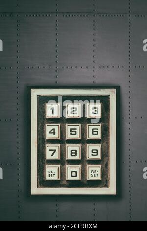 Pavé numérique rétro avec boutons de réinitialisation et de chiffres sur un mur gris foncé Banque D'Images