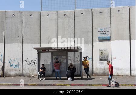 Camp de réfugiés de Shurafat, Israël. 31 août 2020. Les Palestiniens attendent le bus devant le mur de séparation israélien dans le camp de réfugiés de Shurafat, près de Jérusalem, le lundi 31 août 2020. Le conseiller présidentiel américain Jared Kushner a appelé les Palestiniens à reprendre les négociations avec Israël et à ne pas être « dans le passé » à leur arrivée à l'AUE lors du premier vol direct entre Israël et Abu Dhabi. Photo par Debbie Hill/UPI crédit: UPI/Alay Live News Banque D'Images