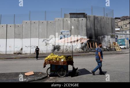 Camp de réfugiés de Shurafat, Israël. 31 août 2020. Un palestinien vend des bananes à côté du mur de séparation israélien dans le camp de réfugiés de Shurafat, près de Jérusalem, le lundi 31 août 2020. Le conseiller présidentiel américain Jared Kushner a appelé les Palestiniens à reprendre les négociations avec Israël et à ne pas être « dans le passé » à leur arrivée à l'AUE lors du premier vol direct entre Israël et Abu Dhabi. Photo par Debbie Hill/UPI crédit: UPI/Alay Live News Banque D'Images