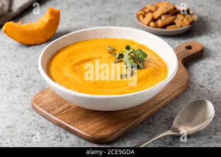 Soupe de potiron à la crème garnir les microverts sur le gris . Gros plan. Banque D'Images