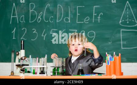 Retour à l'école. Élève regardant à travers le microscope . élève fait des expériences scientifiques avec le microscope en laboratoire. Petit garçon au camp scientifique. Petit garçon utilisant le microscope à la leçon d'école. Préparation aux examens. Banque D'Images