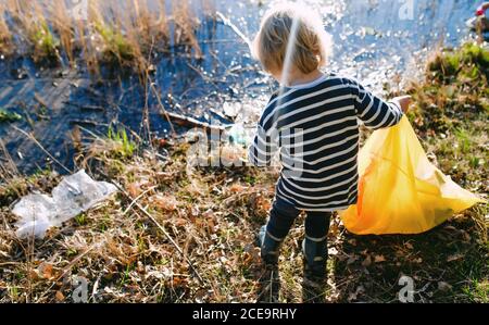 Petit enfant méconnaissable collectant des déchets à l'extérieur dans la nature, concept de blogging. Banque D'Images