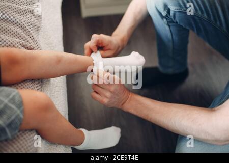 Père aidant la fille à habiller l'uniforme et la préparation des chaussettes de retour à école Banque D'Images