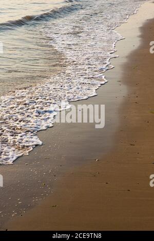 Petites vagues et ondulations sur une plage de sable doré. Tôt le matin lumière du soleil Banque D'Images