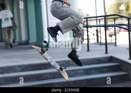 Petit garçon à cheval sur un skateboard en ville Banque D'Images