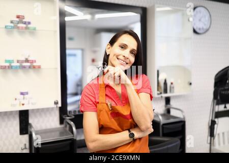 Coiffeur professionnel tenir des ciseaux à la main dans le salon de beauté. Banque D'Images