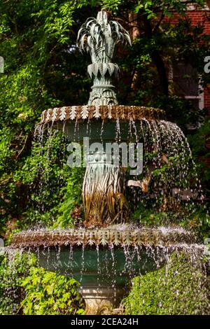 Une fontaine décorative en laiton sculptée en forme de feuilles et de plantes. Il a un pôle central où l'eau monte et deux niveaux de plateaux d'eau gradua Banque D'Images