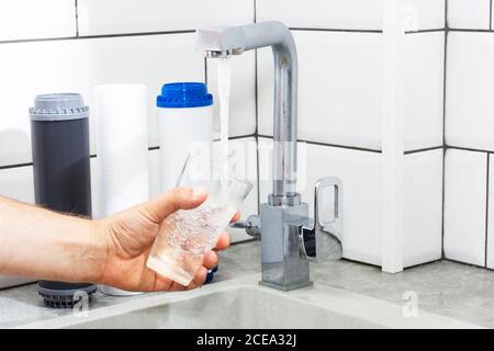 Le robinet d'où s'écoule l'eau. Soif étouffant. Problèmes d'eau dans certains pays.le verre est rempli d'eau. Banque D'Images